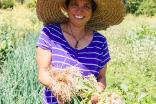 Jody of Jody's Farms holding a bushel of onions